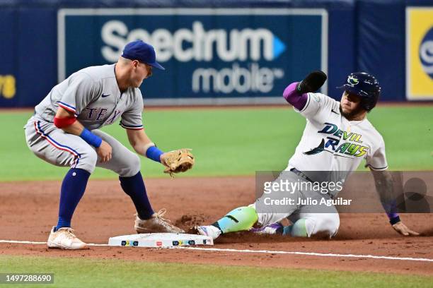 Harold Ramirez of the Tampa Bay Rays steals third base from under Josh Jung of the Texas Rangers in the third inning at Tropicana Field on June 09,...