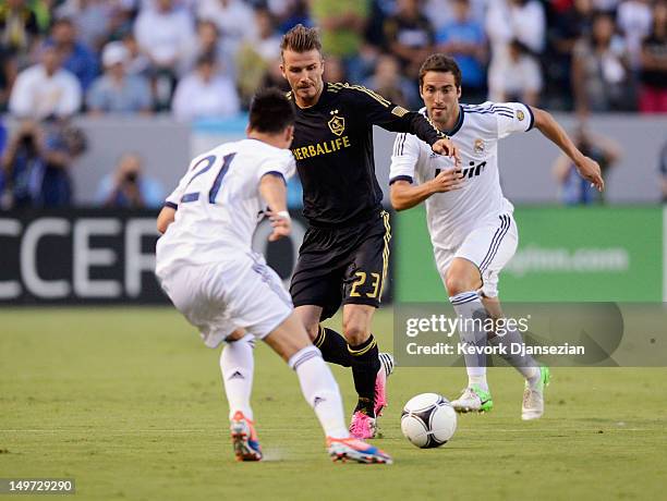 David Beckham of Los Angeles Galaxy maneuvers the ball in between Gonzalo Higuaín and José Maria Callejón of Real Madrid during the World Football...