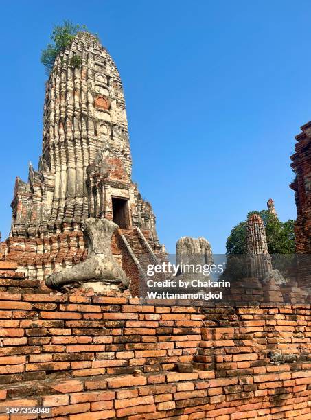 stupa of wat chaiwattanaram and headless sitting buddha statue - an ancient buddhist thai temple in ayutthaya historic park. - ayuthaya stock pictures, royalty-free photos & images