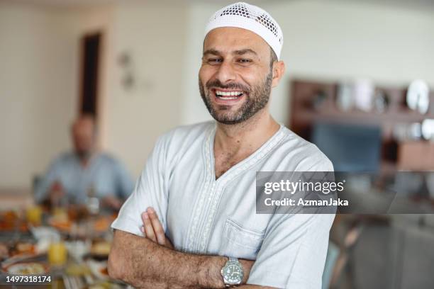 portrait en gros plan d’un père du moyen-orient souriant et debout devant une table à manger - arabie photos et images de collection