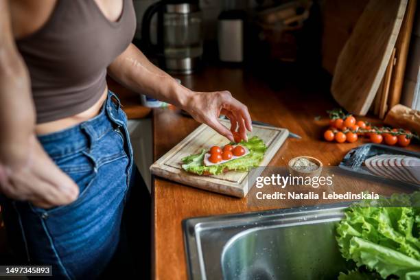 joyful independence: heartwarming scene of a woman with an amputated hand finding joy and fulfillment in her ability to independently prepare a scrumptious sandwich with crisp lettuce and juicy tomatoes. - grilled cheese stock pictures, royalty-free photos & images