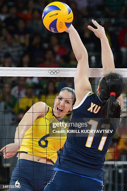 Brazil's Thaisa Menezes spikes as China's Xu Yunli attempts to block during the Women's preliminary pool B volleyball match between Brazil and China...