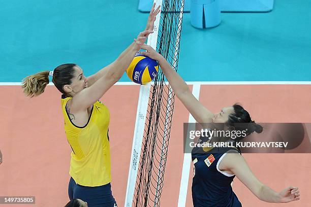 Brazil's Thaisa Menezes spikes as China's Chu Jinling attempts to block during the Women's preliminary pool B volleyball match between Brazil and...
