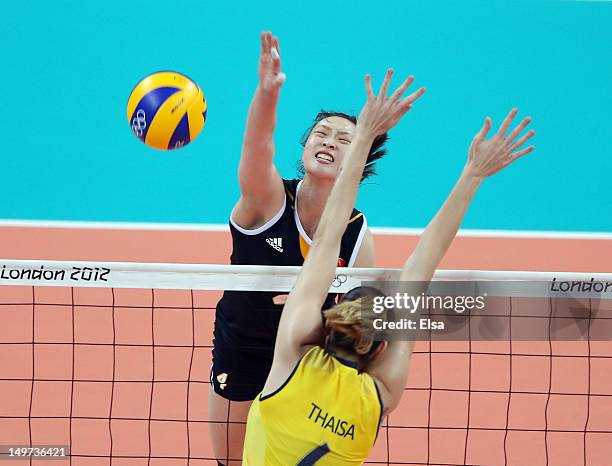 Ruoqi Hui of China spikes the ball as Thaisa Menezes of Brazil defends during Women's Volleyball on Day 7 of the London 2012 Olympic Games at Earls...