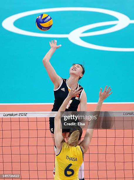 Ruoqi Hui of China spikes the ball as Thaisa Menezes of Brazil defends during Women's Volleyball on Day 7 of the London 2012 Olympic Games at Earls...