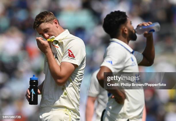 Cameron Green of Australia and Mohammed Siraj take a break during day four of the ICC World Test Championship Final between Australia and India at...