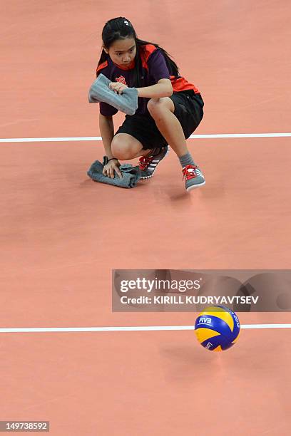 An assistant referee cleans the court during the Women's preliminary pool B volleyball match between Brazil and China in the 2012 London Olympic...