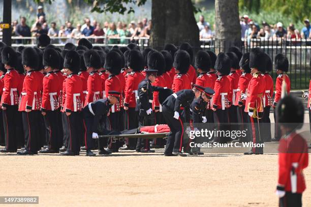 Welsh Guardsman is stretchered away while Prince William, Prince of Wales Carries Out The Colonel's Review at Horse Guards Parade on June 10, 2023 in...