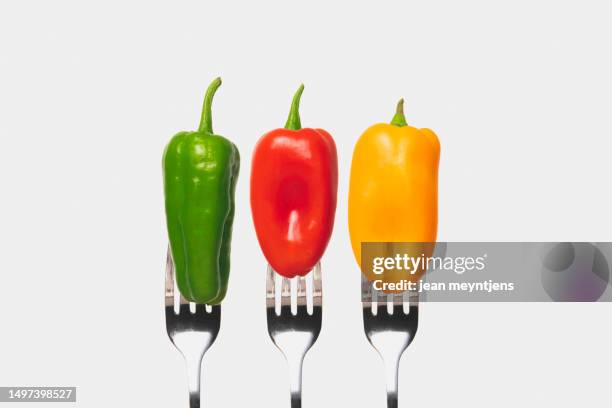 close up of fresh bell peppers on forks - orange bell pepper fotografías e imágenes de stock