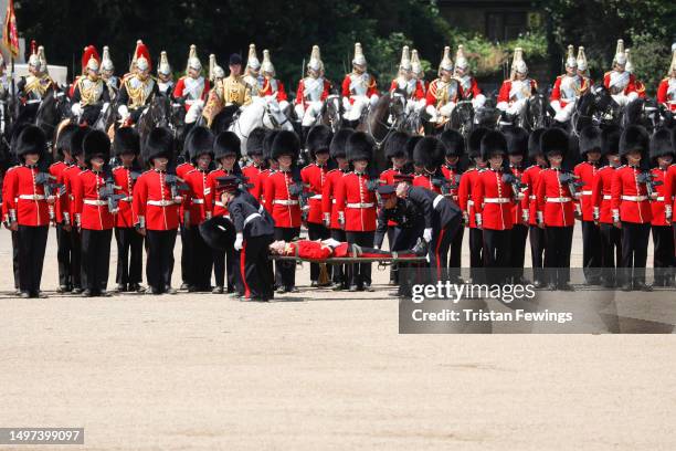 Welsh Guardsman is stretchered away while Prince William, Prince of Wales Carries Out The Colonel's Review at Horse Guards Parade on June 10, 2023 in...