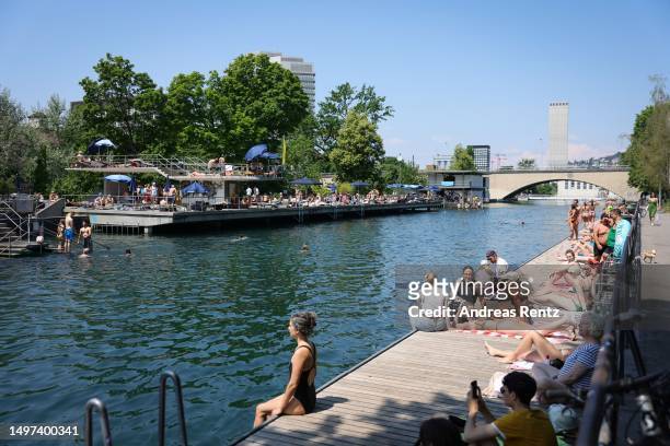 People enjoy the warm weather along the river Limmat on June 10, 2023 in Zurich, Switzerland. Temperatures are reaching 25 degrees celsius around...