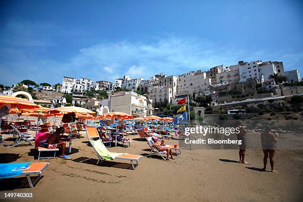 People are seen sunbathing on the beach in the coastal resort of Sperlonga, Italy, on Thursday, Aug. 2, 2012. Italy's economy shrank for a third...