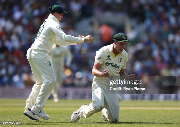 Cameron Green of Australia celebrates with Steve Smith of Australia after taking a catch to dismiss off Shubman Gill of India the bowling of Scott...