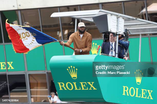 LeBron James waves the French Flag to start the race during the 100th anniversary of the 24 Hours of Le Mans at the Circuit de la Sarthe June 10,...