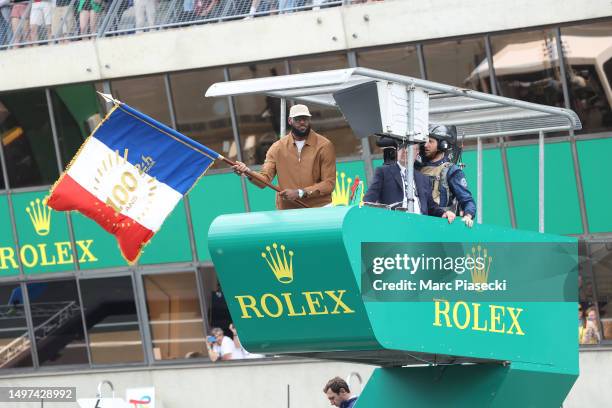 LeBron James waves the French Flag to start the race during the 100th anniversary of the 24 Hours of Le Mans at the Circuit de la Sarthe June 10,...