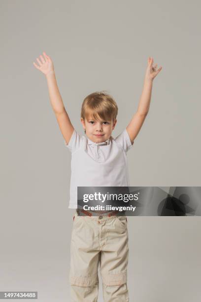 blonder junge in t-shirt und hose im studio auf weißem hintergrund. kindermode. kindheit - t 6 stock-fotos und bilder