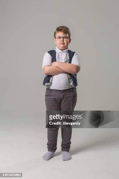 blonde boy in glasses and jeans with vest in studio on gray background. child. childhood. schoolboy - childhood obesity stock pictures, royalty-free photos & images
