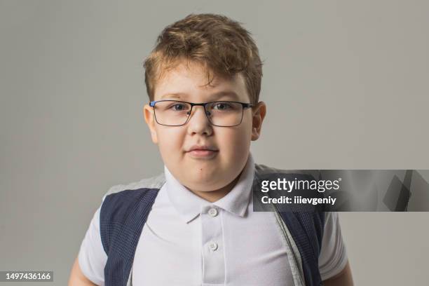 blonde boy in glasses and jeans with vest in studio on gray background. child. childhood. schoolboy - chubby stock pictures, royalty-free photos & images