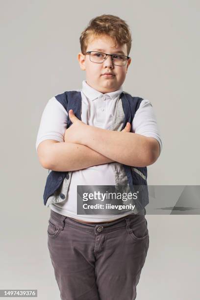 blonde boy in glasses and jeans with vest in studio on gray background. child. childhood. schoolboy - childhood obesity stock pictures, royalty-free photos & images