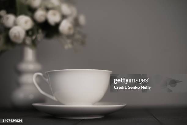 white cups and saucers with vase and flowers on dark kitchen background close up and copy space. - restaurant logo stock pictures, royalty-free photos & images