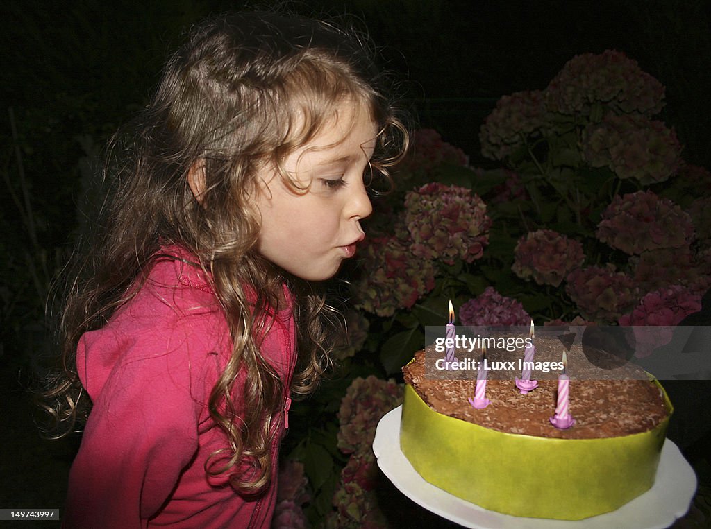 Birthday girl blowing out candles on a cake