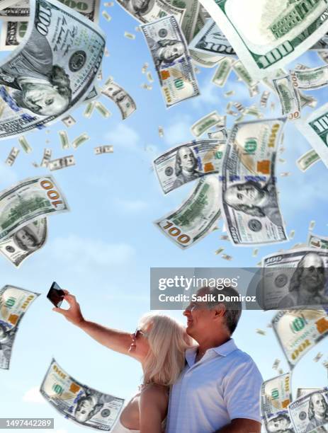 outdoor portrait of well dressed middle age caucasian adult woman and man couple under falling large group of money - woman filling out paperwork stock-fotos und bilder