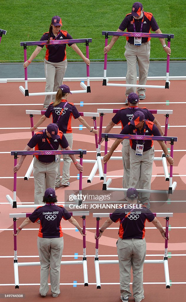 Staff set up hurdles during the athletic