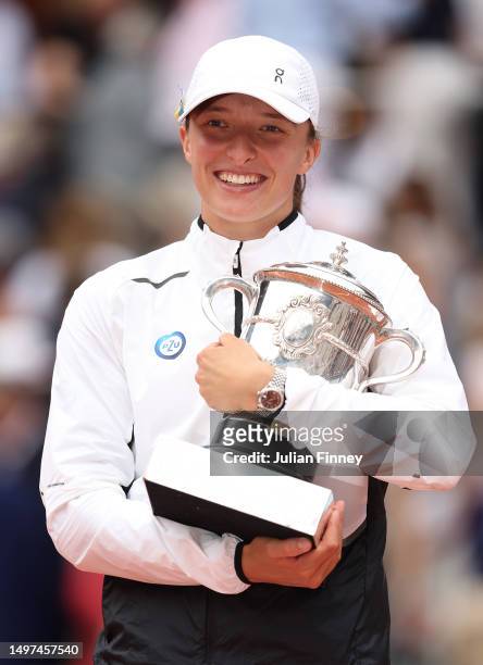 Iga Swiatek of Poland celebrates with her winners trophy as the lid falls off after victory against Karolina Muchova of Czech Republic in the Women's...