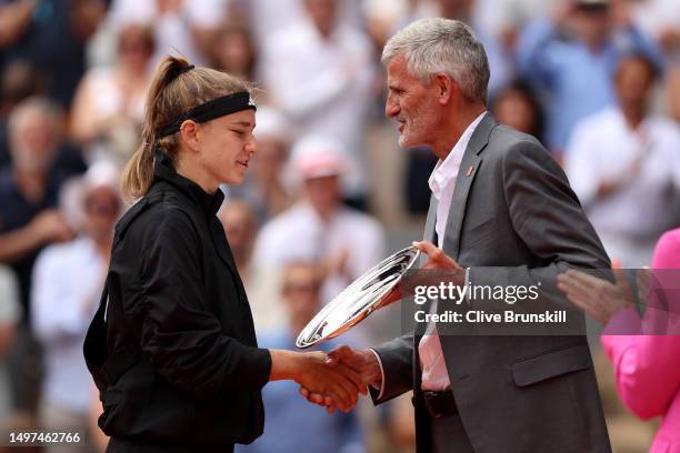 Karolina Muchova of Czech Republic is presented with her runners up trophy by Gilles Moretton, President of the FFT, after defeat to Iga Swiatek of...