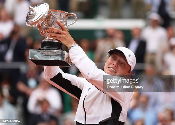 Iga Swiatek of Poland celebrates with her winners trophy as the lid falls off after victory against Karolina Muchova of Czech Republic in the Women's...