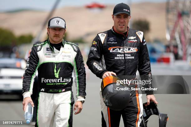 Jeffrey Earnhardt, driver of the ForeverLawn Chevrolet, and Alex Labbe, driver of the RSS Racing Ford, walk the grid during qualifying for the NASCAR...