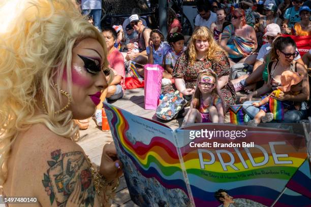 Austin, Tx drag queen Brigitte Bandit reads a book during a drag time story hour at the Waterloo Greenway park on June 10, 2023 in Austin, Texas. The...