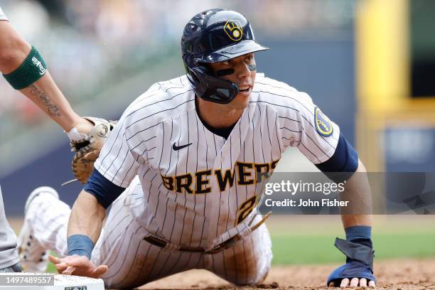 Christian Yelich of the Milwaukee Brewers slides back safely to first base in the third inning against the Oakland Athletics at American Family Field...
