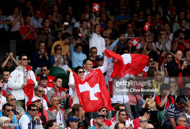 Fans of Roger Federer of Switzerland hold up the Swiss Flag as Federer takes on Juan Martin Del Potro of Argentina in the Semifinal of Men's Singles...