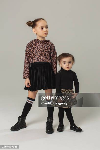 two blonde girls in skirt in studio on white background. child. childhood. hair bun hairstyle. summer fashion - high hair bun stock pictures, royalty-free photos & images