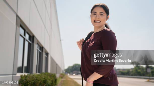 early twenties female and latino college grad arrives at the office on an early morning day. - mexican american stock pictures, royalty-free photos & images