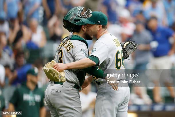 Sam Long celebrates with Shea Langeliers after defeating the Milwaukee Brewers 2-1 in ten innings of the Oakland Athletics at American Family Field...