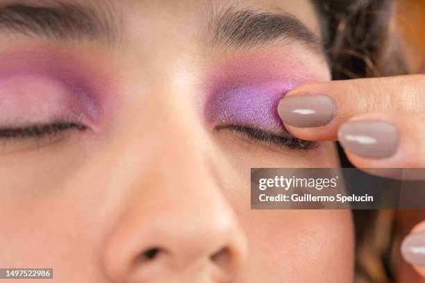 make-up artist using her finger to soften eye shadow - latina makeup fotografías e imágenes de stock
