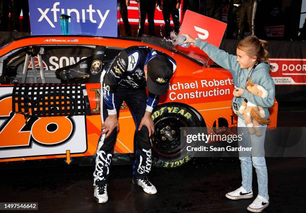 Aric Almirola, driver of the Michael Roberts Construction Ford, celebrates with his daughter, Abby in victory lane after winning the NASCAR Xfinity...