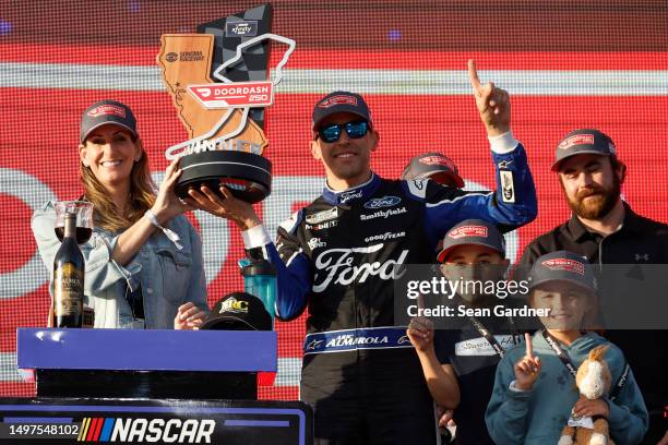 Aric Almirola, driver of the Michael Roberts Construction Ford, celebrates with son, Alex and daughter, Abby in victory lane after winning the NASCAR...