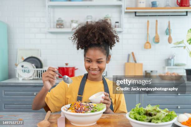 making salad by a woman with dressing - salatdressing stock-fotos und bilder