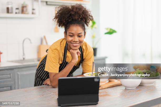 happy young woman preparing food at home - vip room stock pictures, royalty-free photos & images