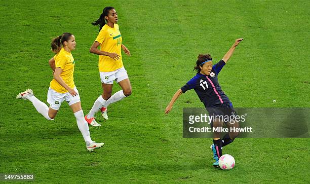 Yuki Ogimi of Japan scores the opening goal despite the efforts of Erika and Bruna of Brazil during the Women's Football Quarter Final match between...
