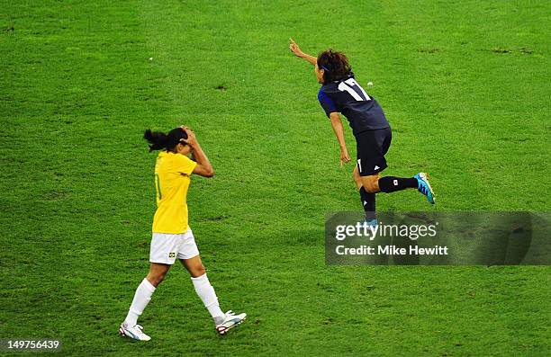 Yuki Ogimi of Japan celebrates after scoring the opening goal as Marta of Brazil holds her head in her hands during the Women's Football Quarter...