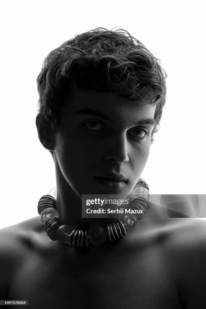 Man with neckless look into camera - stock photo