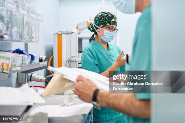 medical staff reading paperwork on a hospital - project heal stockfoto's en -beelden