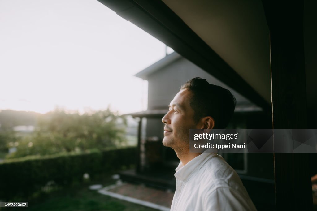 Man pondering in patio at sunset
