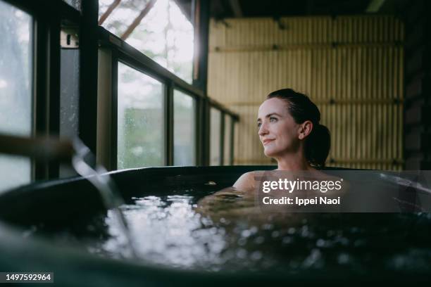 woman taking a bath on balcony in japan - fuente-termal fotografías e imágenes de stock