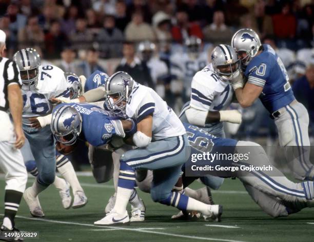 Linebacker Bob Breunig of the Dallas Cowboys tackles fullback Dexter Bussey of the Detroit Lions as offensive linemen Russ Bolinger, Homer Elias and...