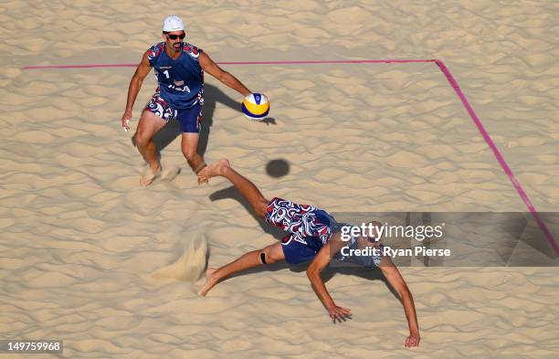 Phil Dalhausser of the United States dives for the ball as Todd Rogers of the United States looks on during the Men's Beach Volleyball Round of 16...